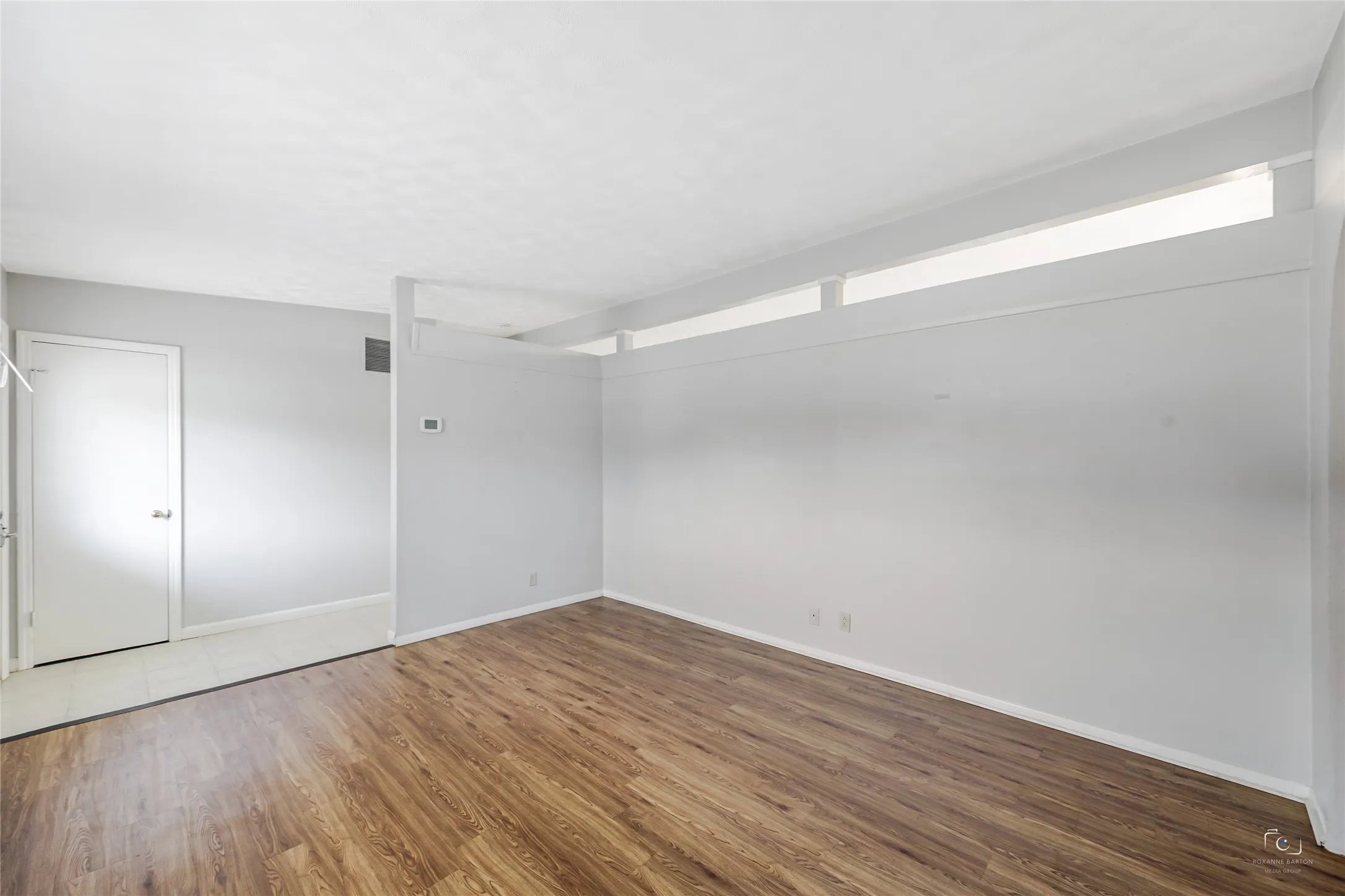 Another view of one of the two living areas open to foyer with a coat closet and note the wall space ideal for art work or placement of furniture - could even serve as a second dining room!