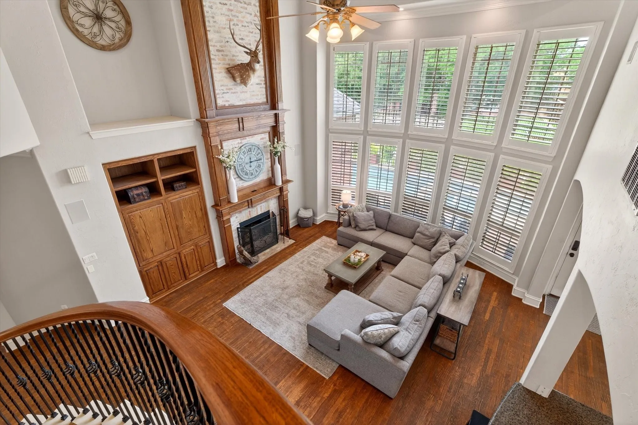 From above, the living room showcases the home’s two-story ceilings, dramatic fireplace, and wall of windows overlooking the backyard.