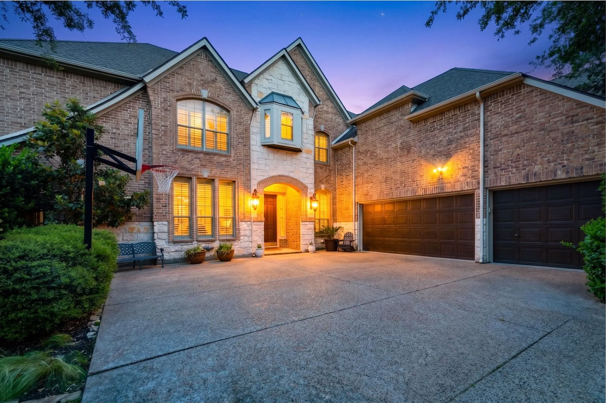At twilight, the home’s warm exterior lighting, mature landscaping, and three-car garage create a polished first impression from the curb. WELCOME HOME!