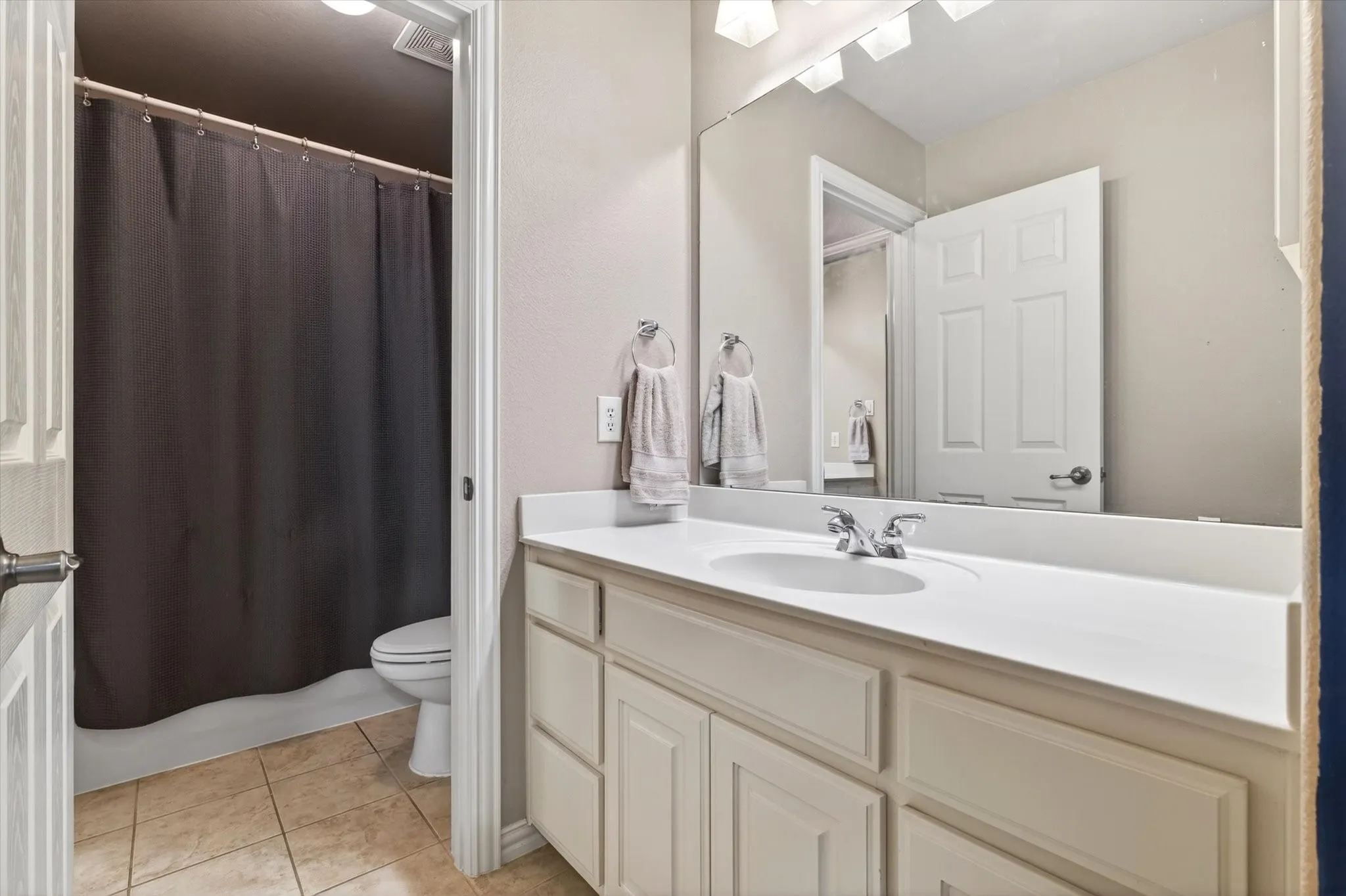 A Jack-and-Jill style bath setup provides convenience between bedrooms, with dual access and practical separation.