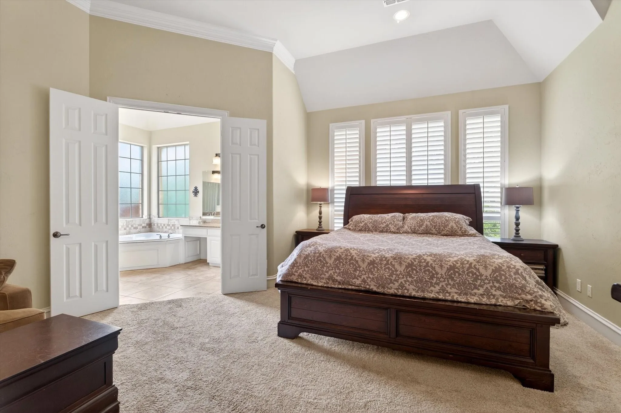 Privately tucked on the main level, the primary suite offers quiet separation from the upstairs bedrooms and main entertaining spaces.