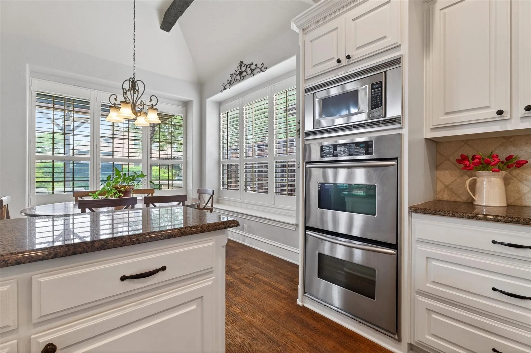 Dual ovens, stainless steel appliances, granite counters, and abundant cabinetry make this kitchen ready for both weeknight dinners and full-scale hosting.