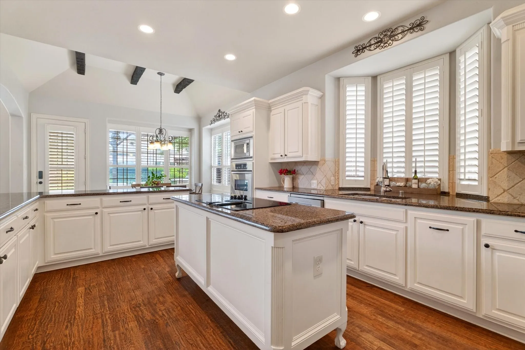 Undermount cabinet lighting, pullout drawers, generous prep space, and a large island make this kitchen both beautiful and practical.
