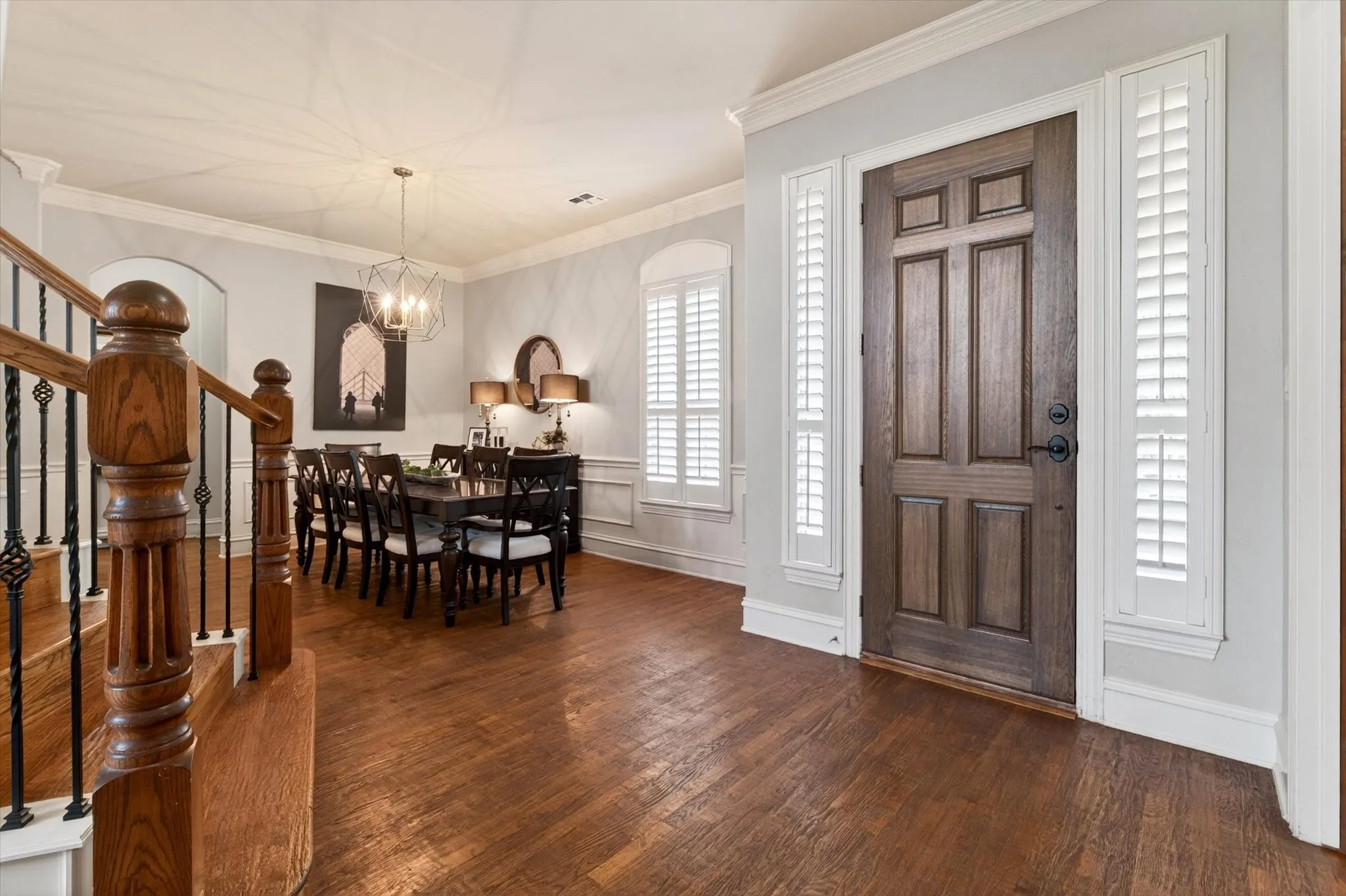From the front door, the home opens beautifully to formal spaces, hardwood flooring, plantation shutters, and that memorable sweeping staircase.