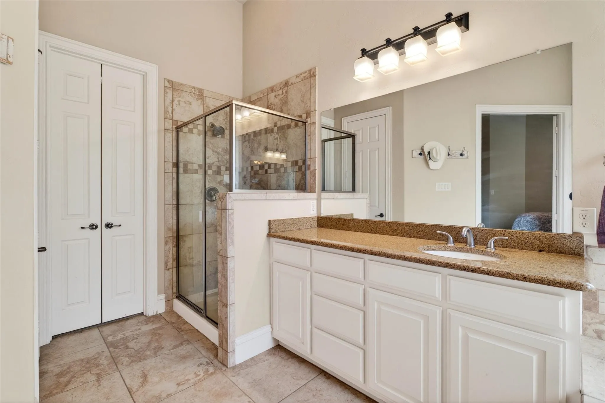 A separate shower, walk-in closet access, and spacious vanity area keep the morning routine from turning into a domestic obstacle course.