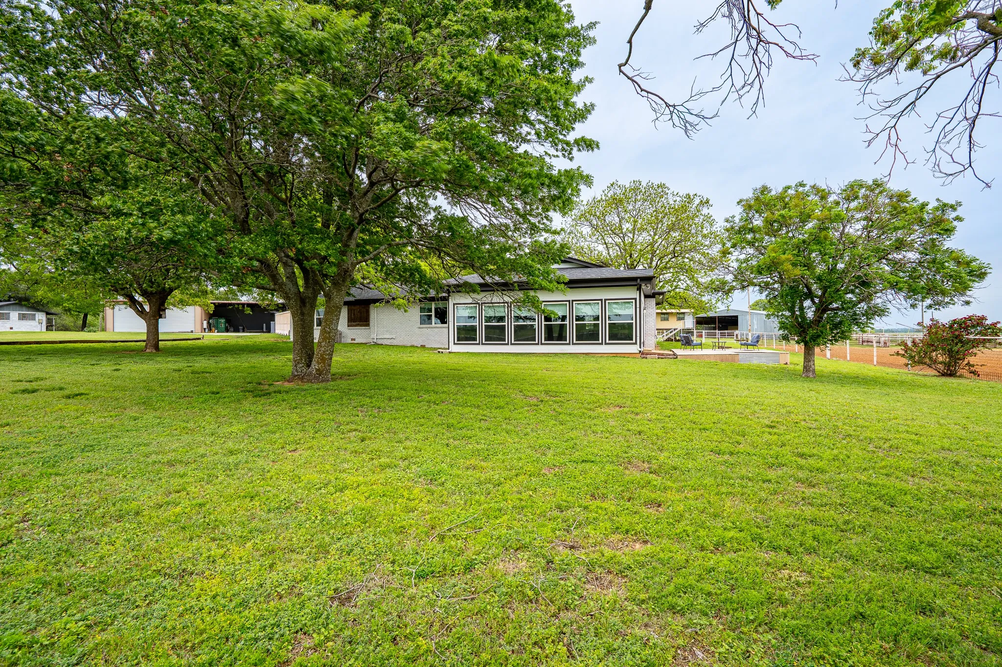 Expansive rear lawn with mature shade trees