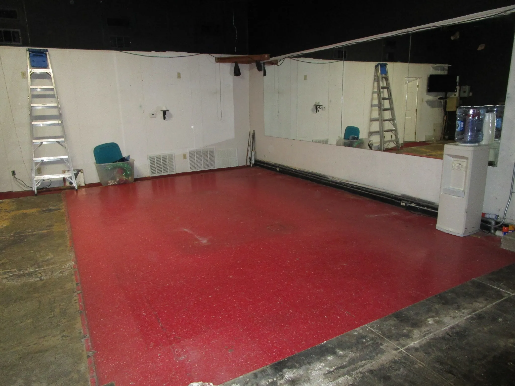 Red-hued flooring with a partial mirrored wall