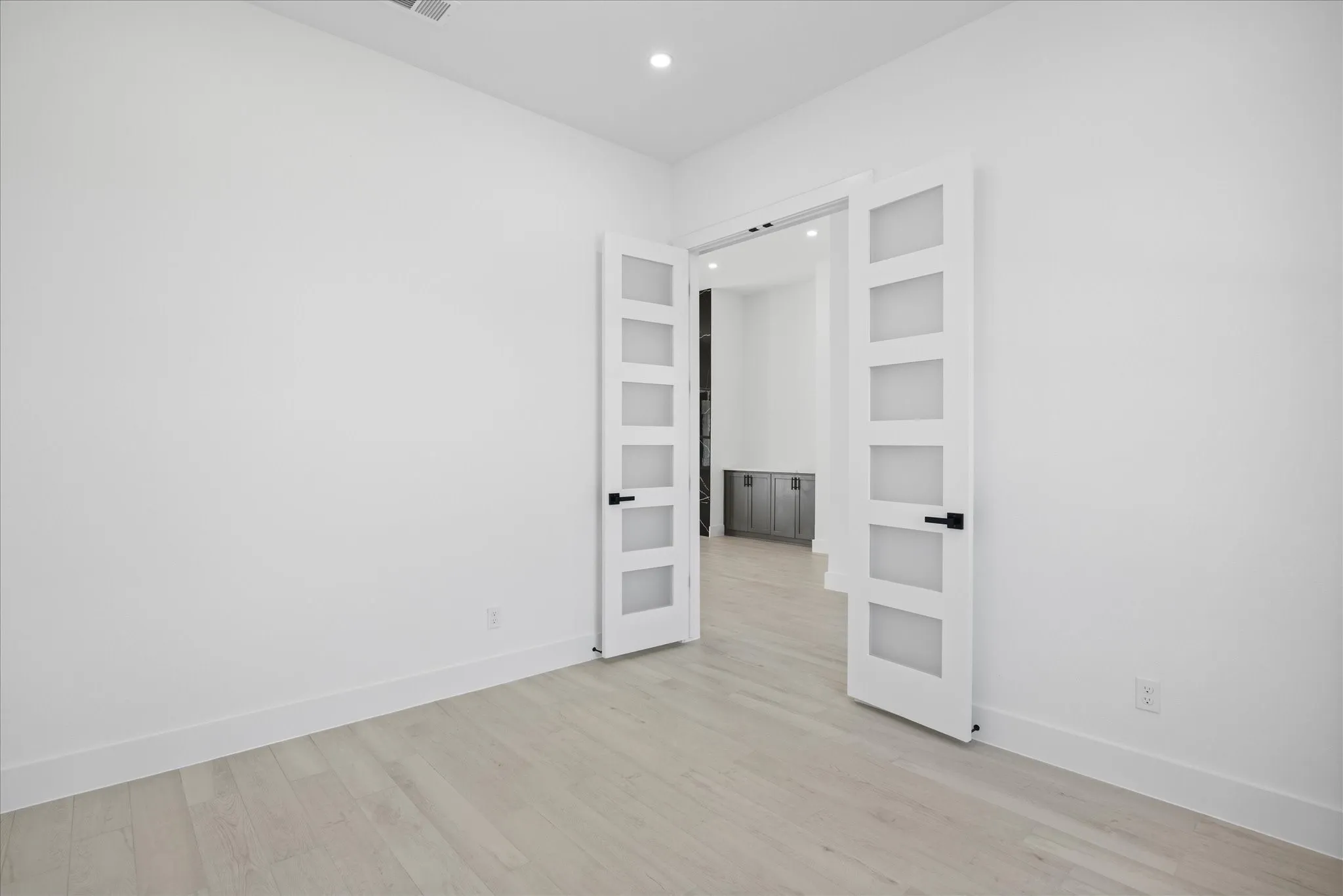 Study Room featuring french doors, light Porcelain Tile-finish flooring, white walls, and recessed lighting and front facing window.