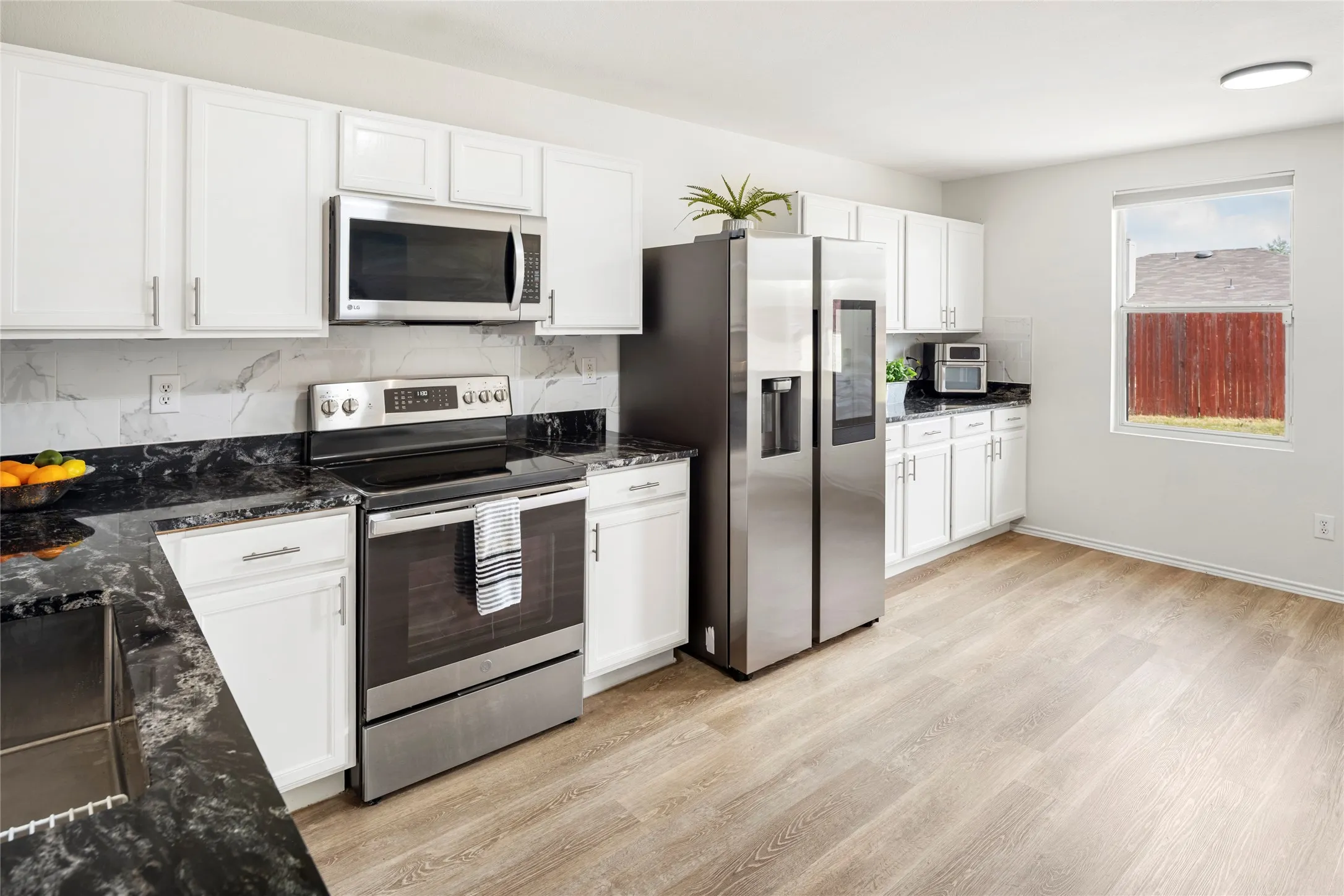 Updated kitchen with stainless steel appliances (fridge stays with home) and upgraded granite countertops and tile backsplash...