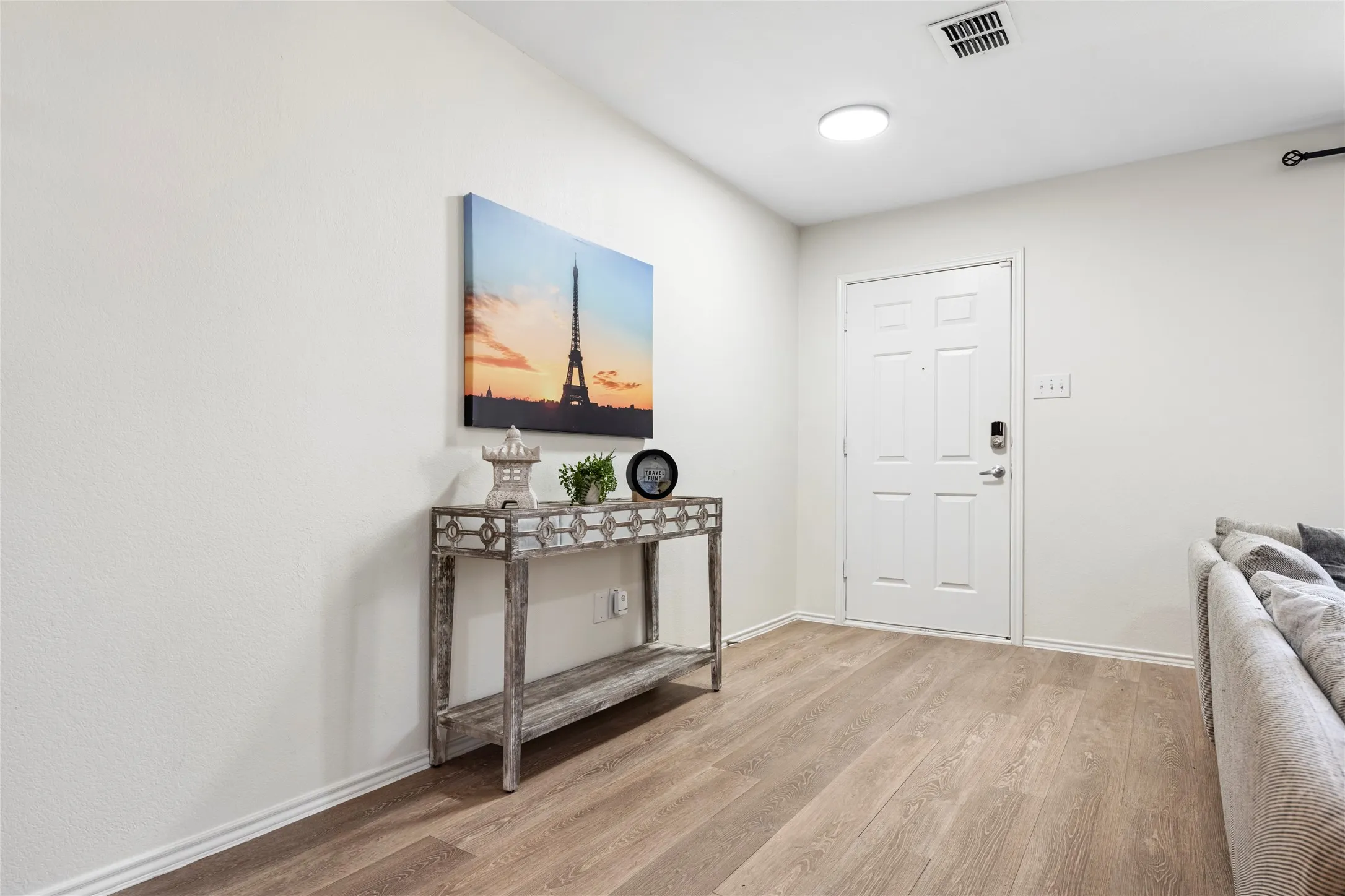 Entryway featuring wood-finish flooring, a six-panel entry door, and a flush-mount ceiling light fixture