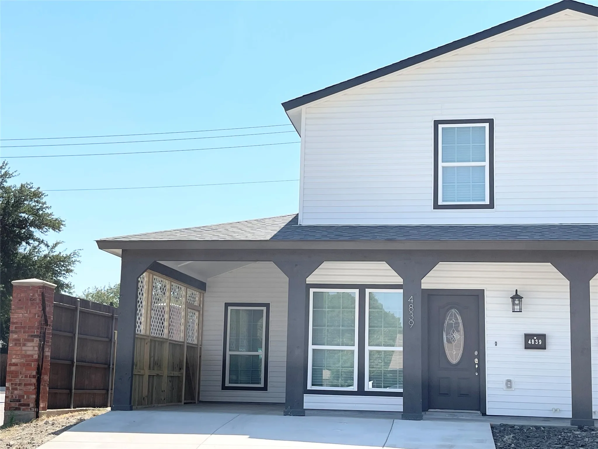 Modern two-story residence featuring white siding and dark trim