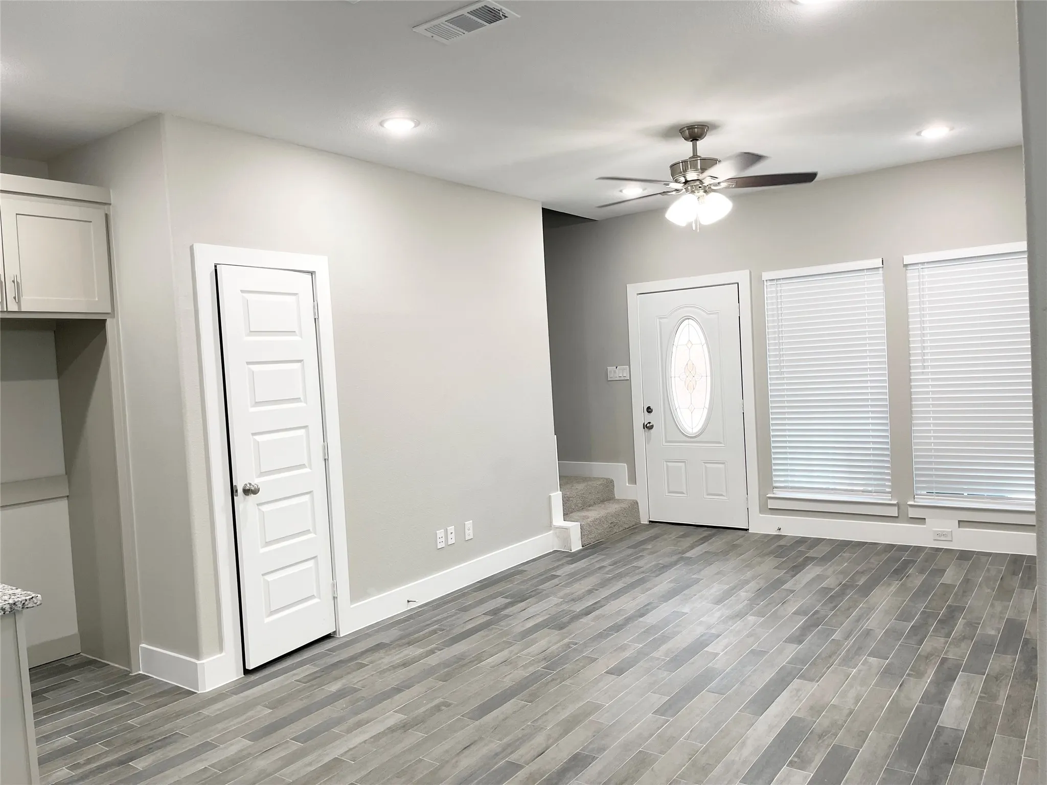 Open living space featuring wood-finish flooring, recessed lighting, and a ceiling fan