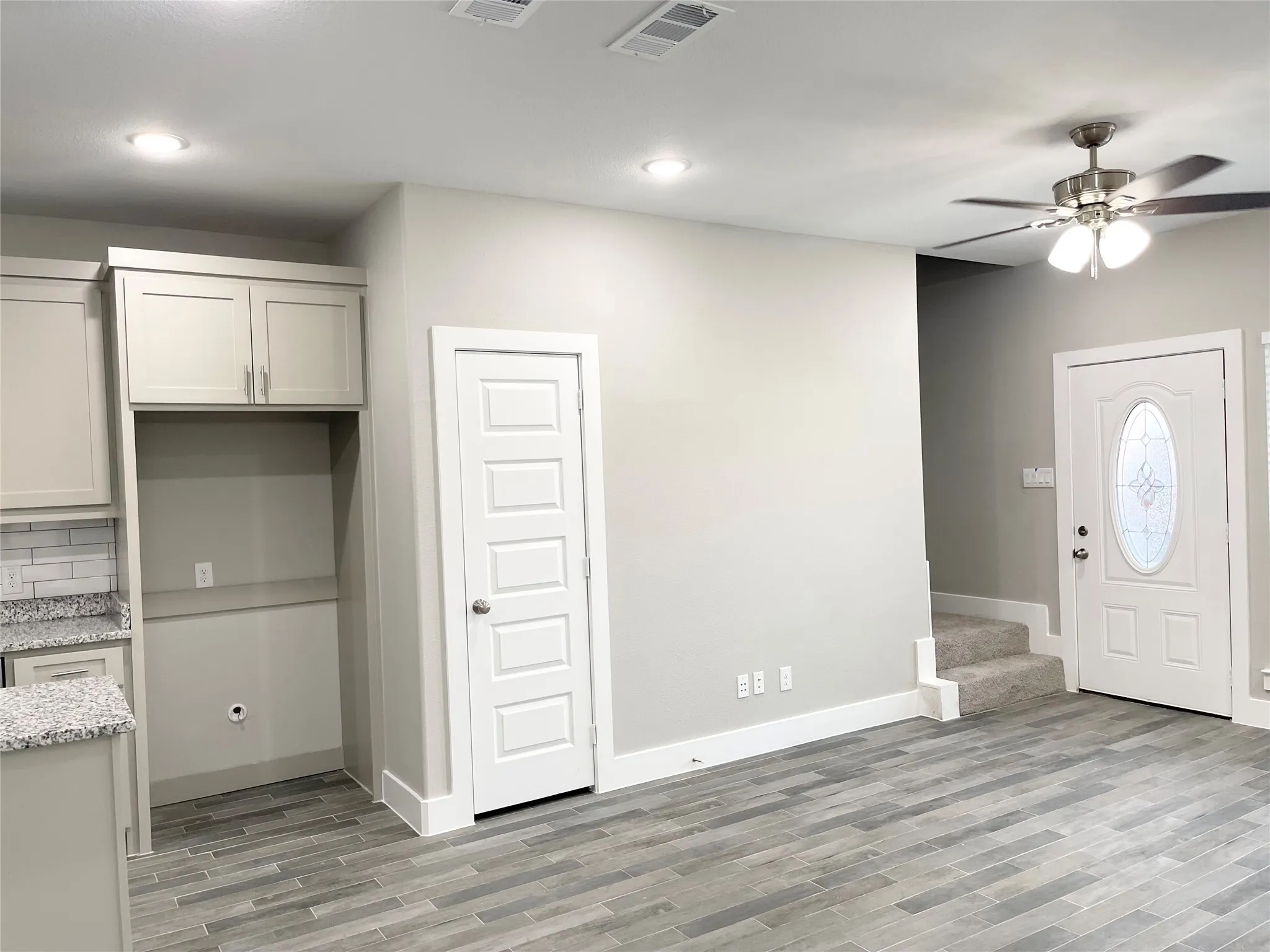 Open concept living area featuring wood-finish flooring, recessed lighting, and a ceiling fan with light fixture