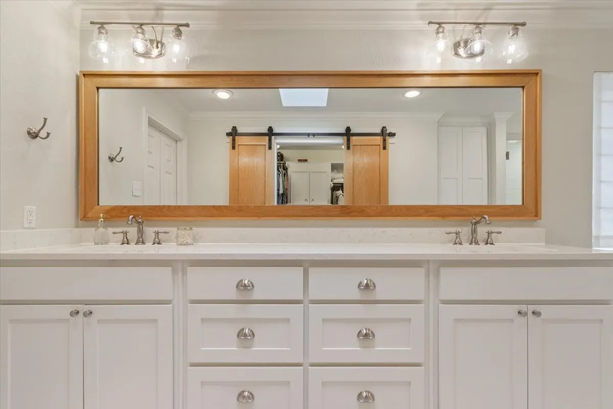 Upstairs dual vanity with white cabinetry, light-toned countertops, and brushed nickel hardware