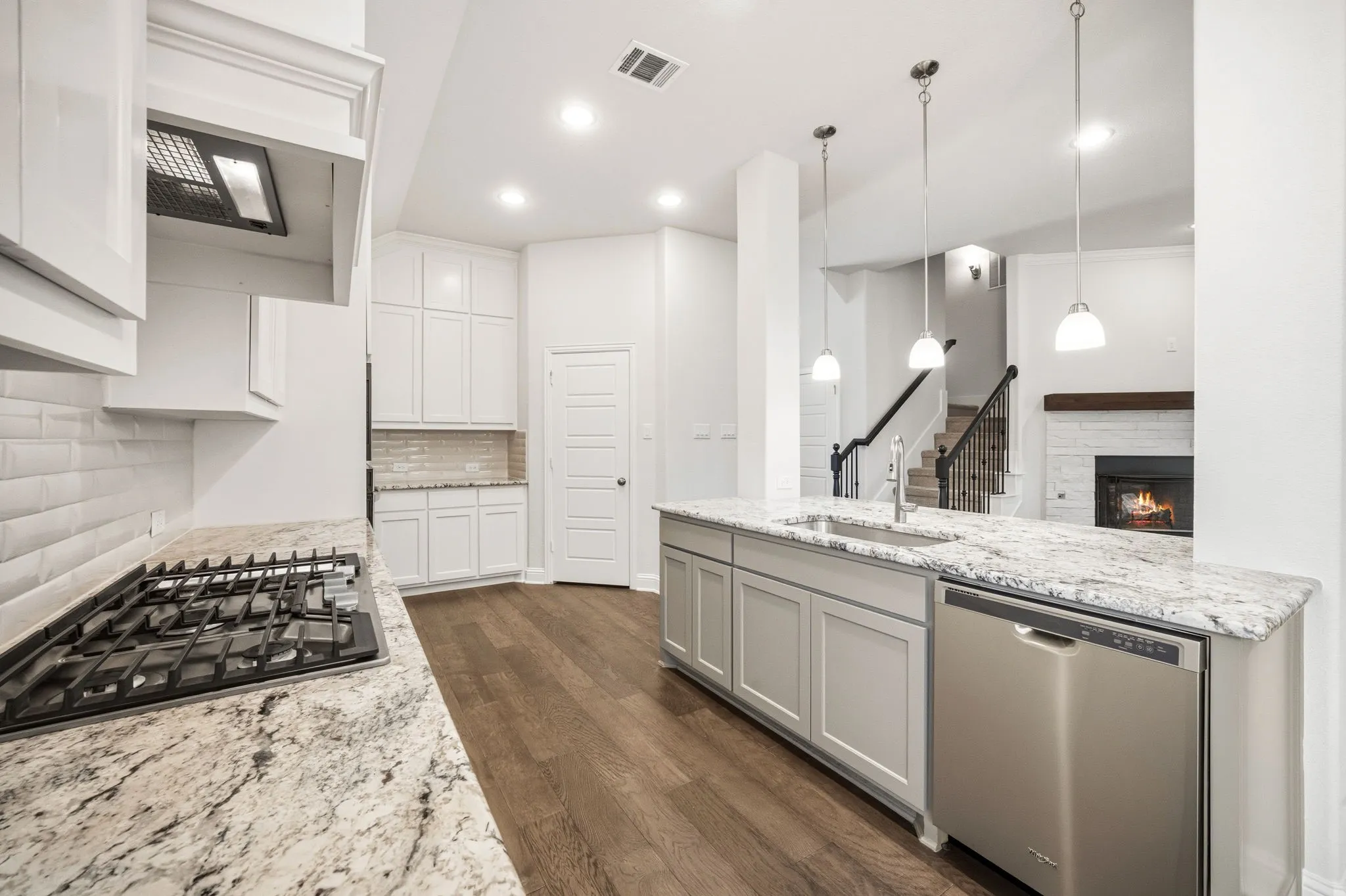Kitchen featuring white cabinetry, granite countertops, a gas cooktop, and wood-finish flooring