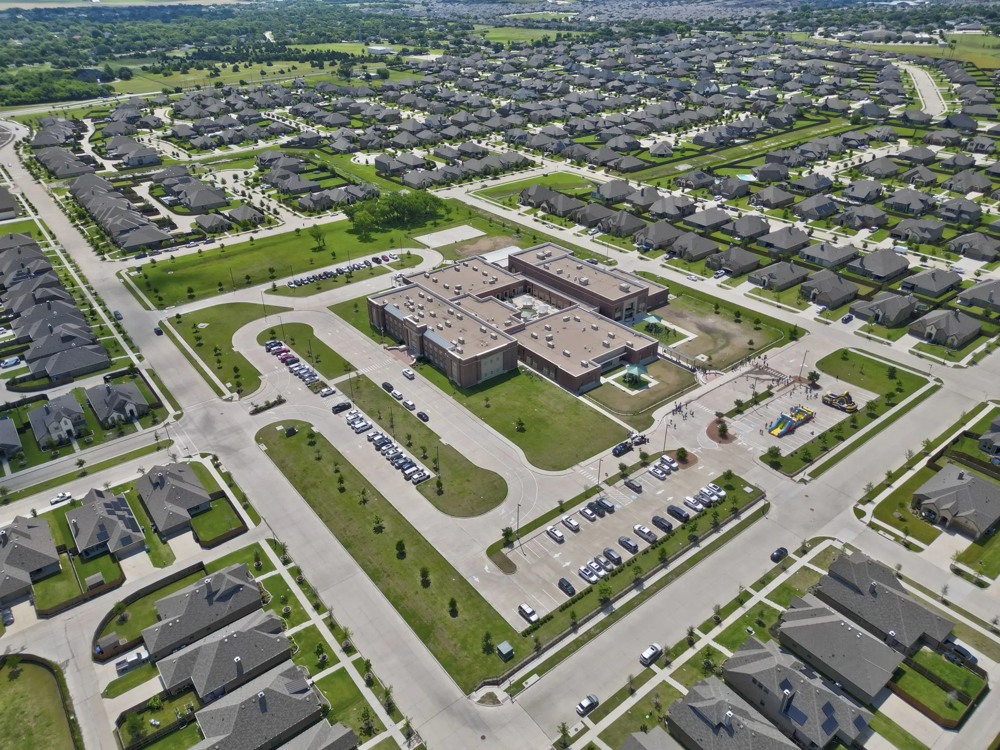 Aerial perspective showcasing a residential community with uniform home designs and surrounding green spaces
