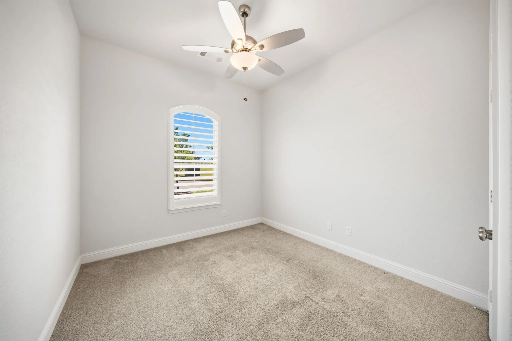Downstairs Guest Bedroom featuring a vaulted ceiling, neutral wall paint, and light-colored carpeting