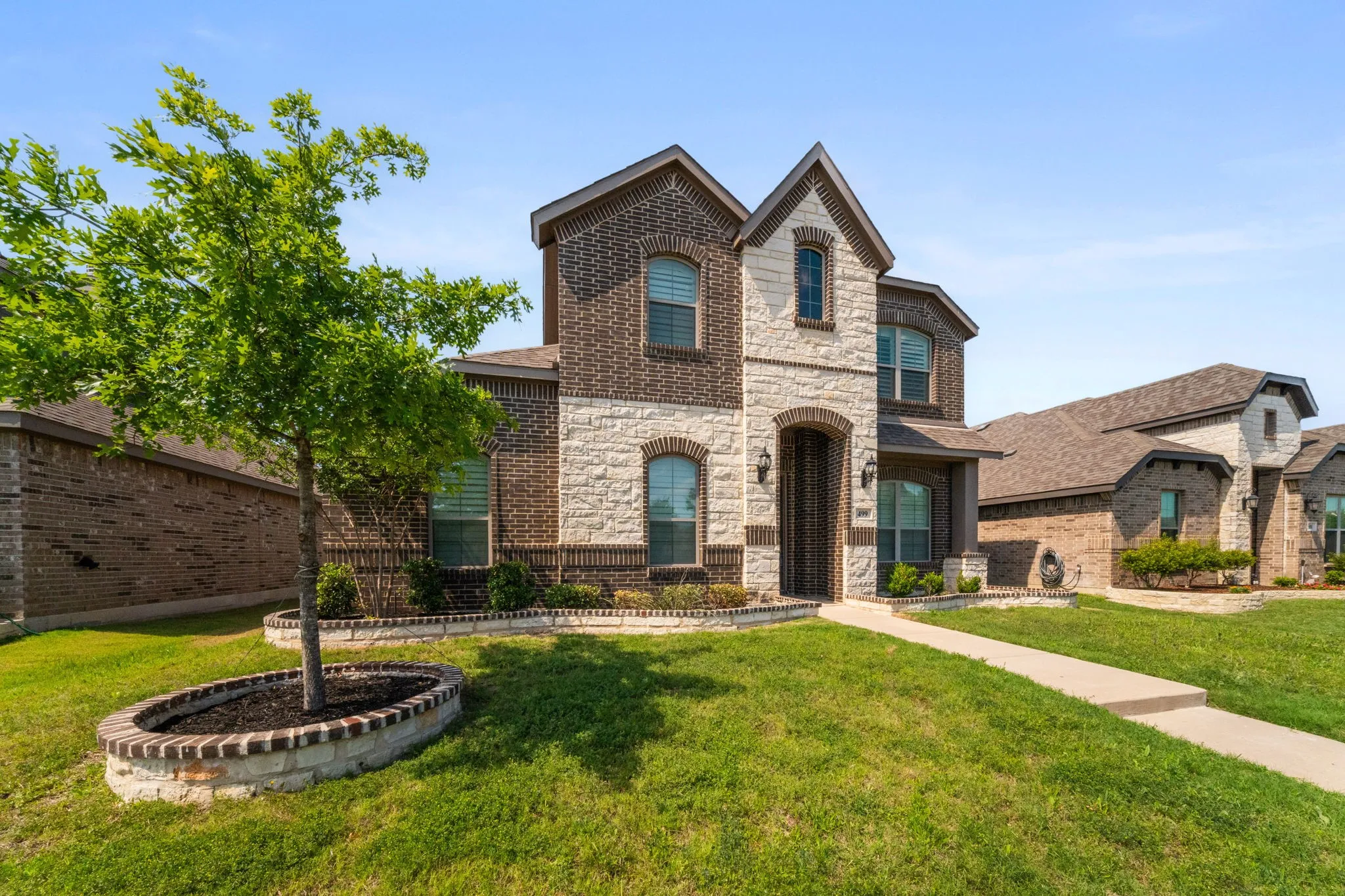 Two-story architectural design featuring brick and stone masonry