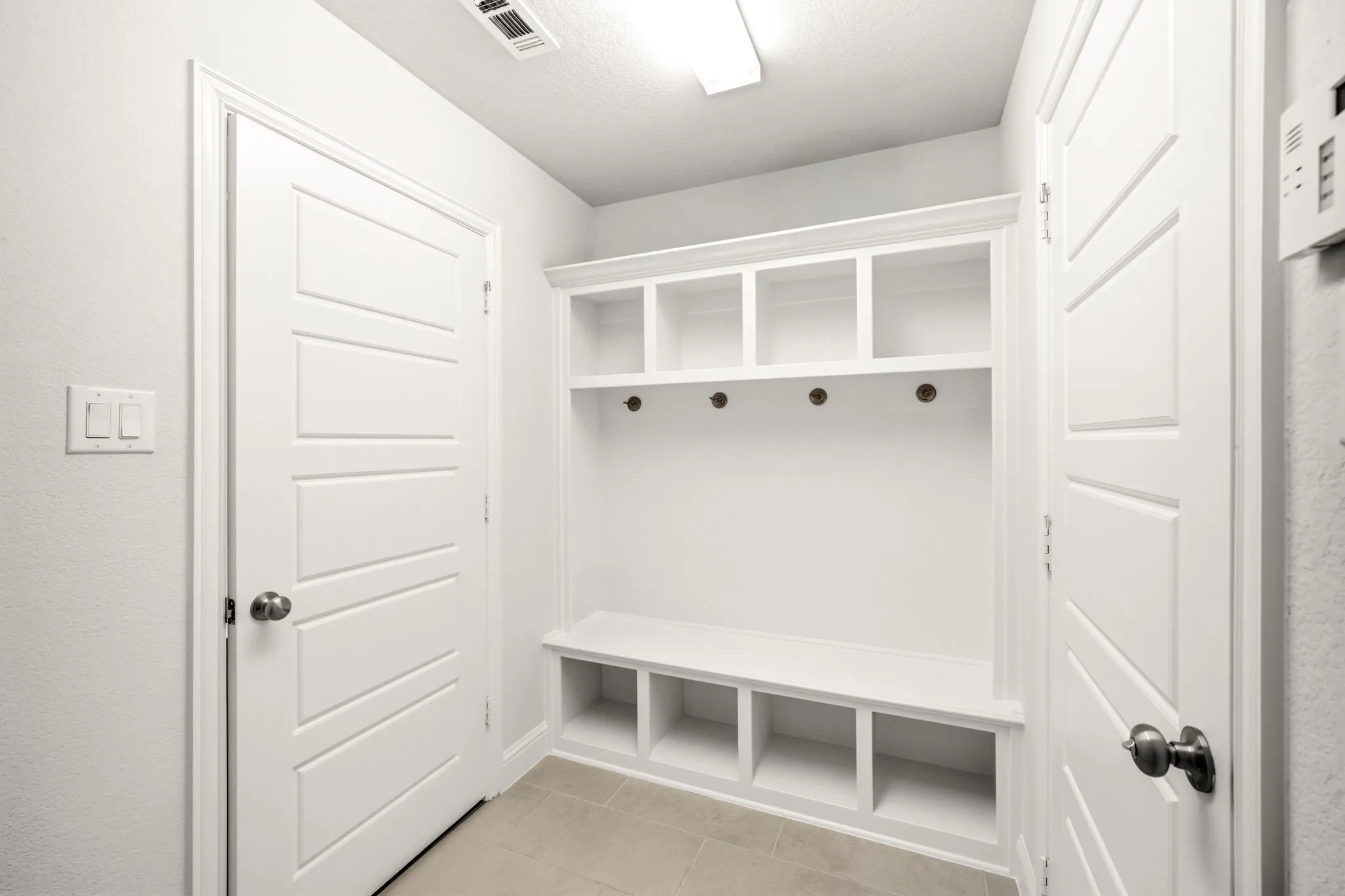 Built-in mudroom bench with cubby storage and coat hooks