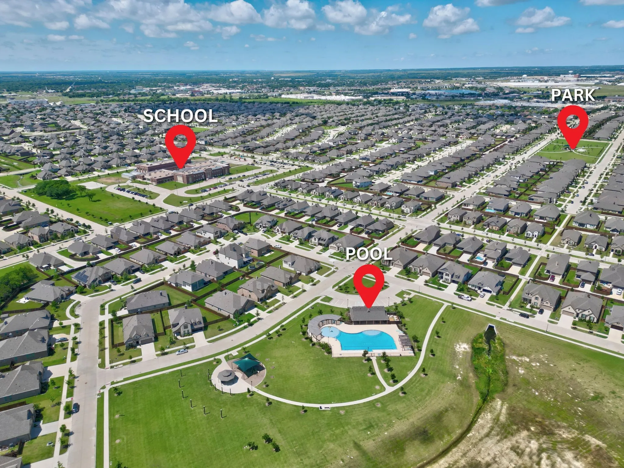 Aerial view of a residential community featuring numerous single-story homes with dark roofs and light-colored exteriors