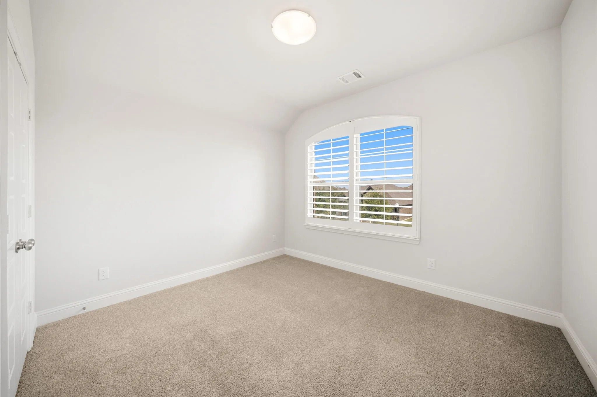 Upstairs Bedroom featuring a vaulted ceiling with a ceiling fan, recessed lighting, an arched window with plantation shutters, and black iron baluster railing