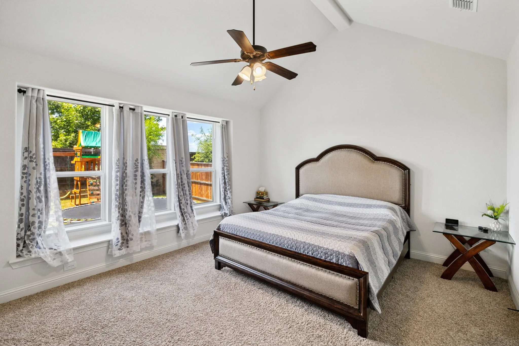 Bright interior featuring a vaulted ceiling and a ceiling fan with light fixture