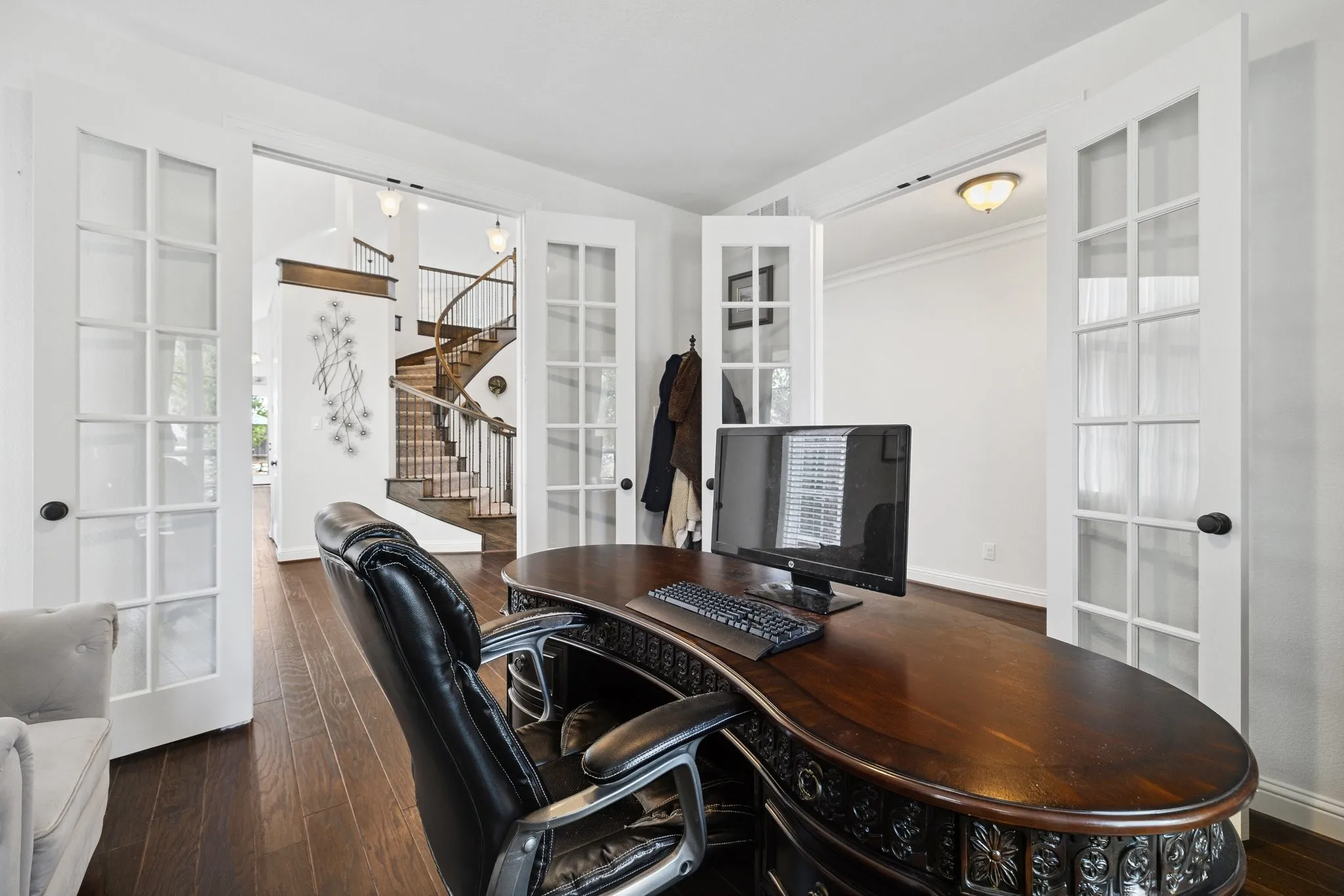 Office space with rich wood-finish flooring and white walls