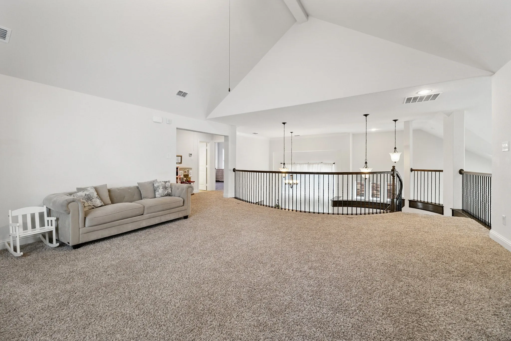 Spacious carpeted upper level featuring a vaulted ceiling