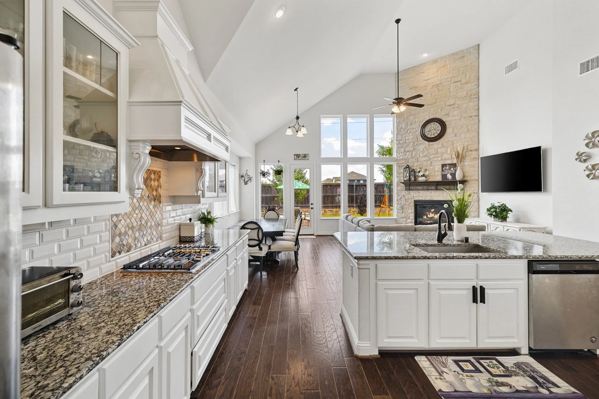 Open-concept interior featuring wood-finish flooring, a vaulted ceiling, and an integrated kitchen