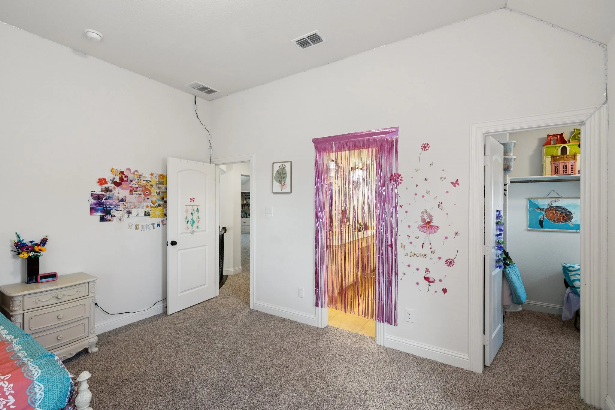 Carpeted interior space featuring white walls and a vaulted ceiling