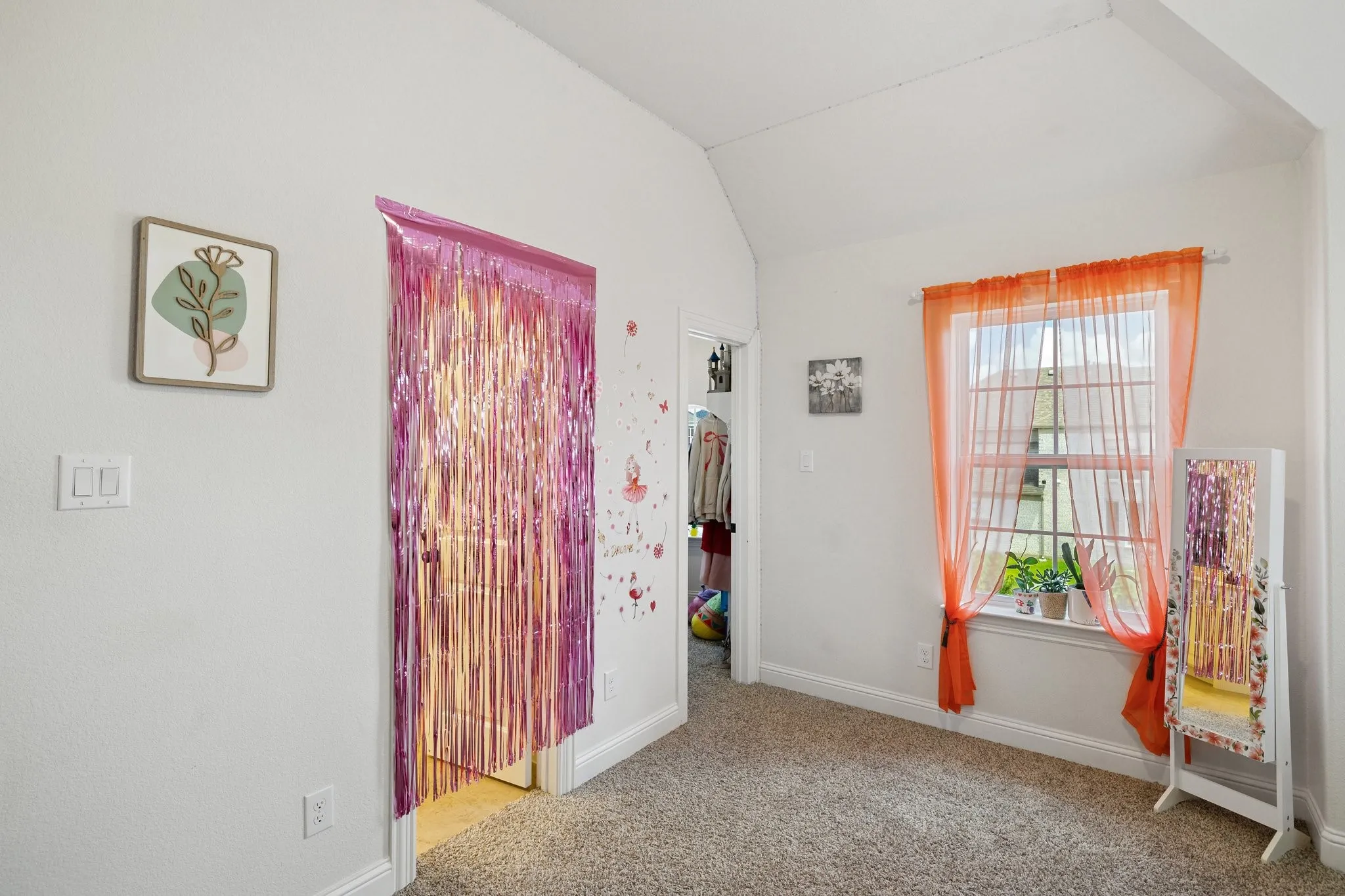 Carpeted room featuring a window with an interior sill, white baseboards, and a vaulted ceiling