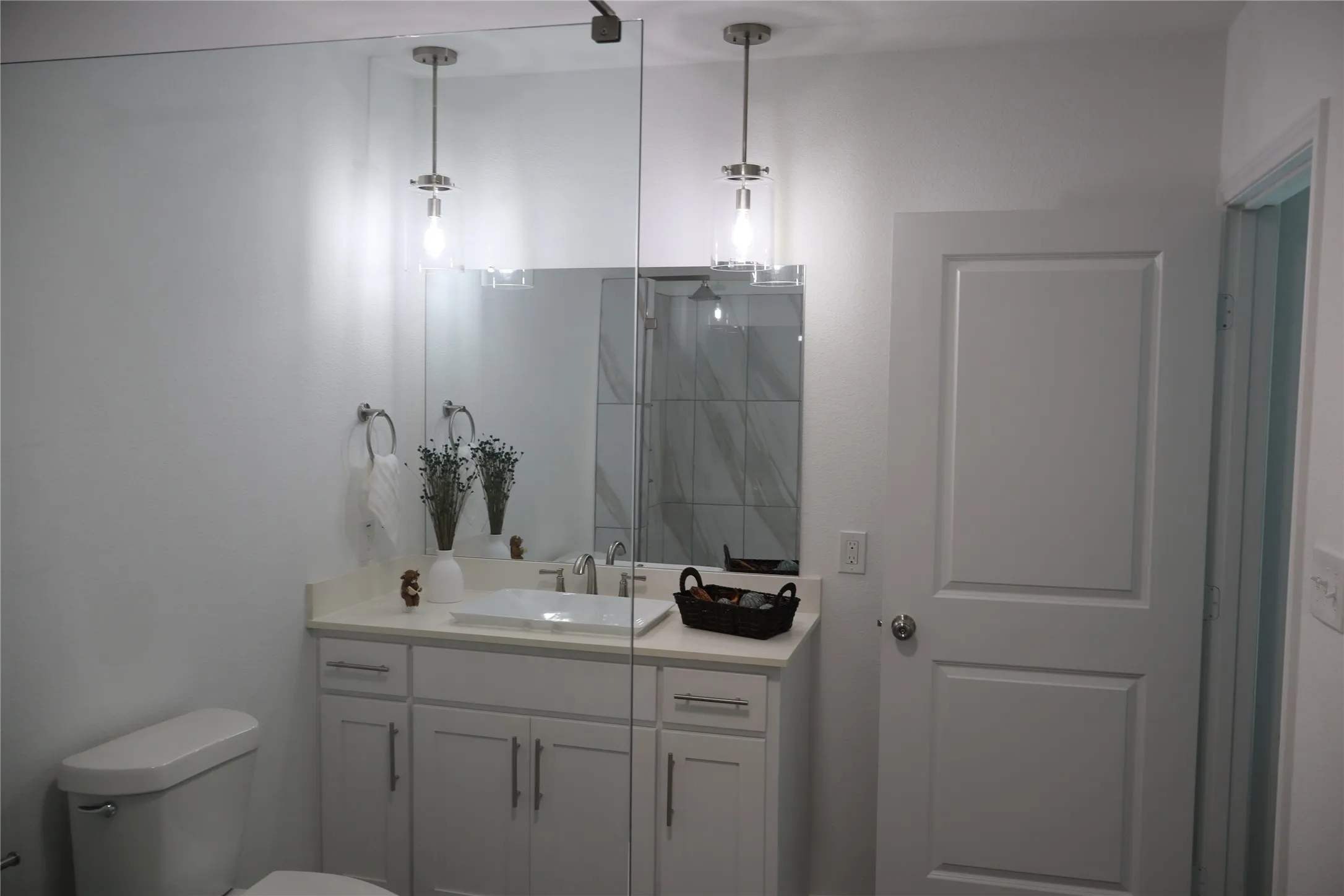 Bathroom featuring a white vanity with an undermount sink, a light-toned countertop, and chrome fixtures