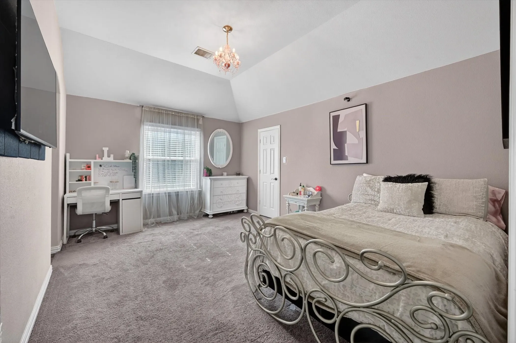 Vaulted ceiling bedroom featuring a crystal chandelier, neutral wall tones, and plush carpeting