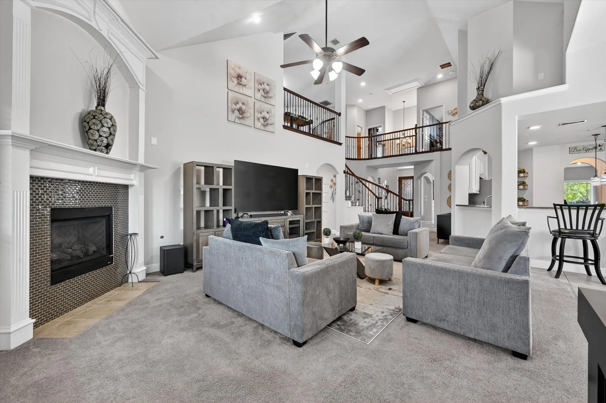 Vaulted ceilings highlight this living area featuring a fireplace with a mosaic tile surround and a decorative mantle