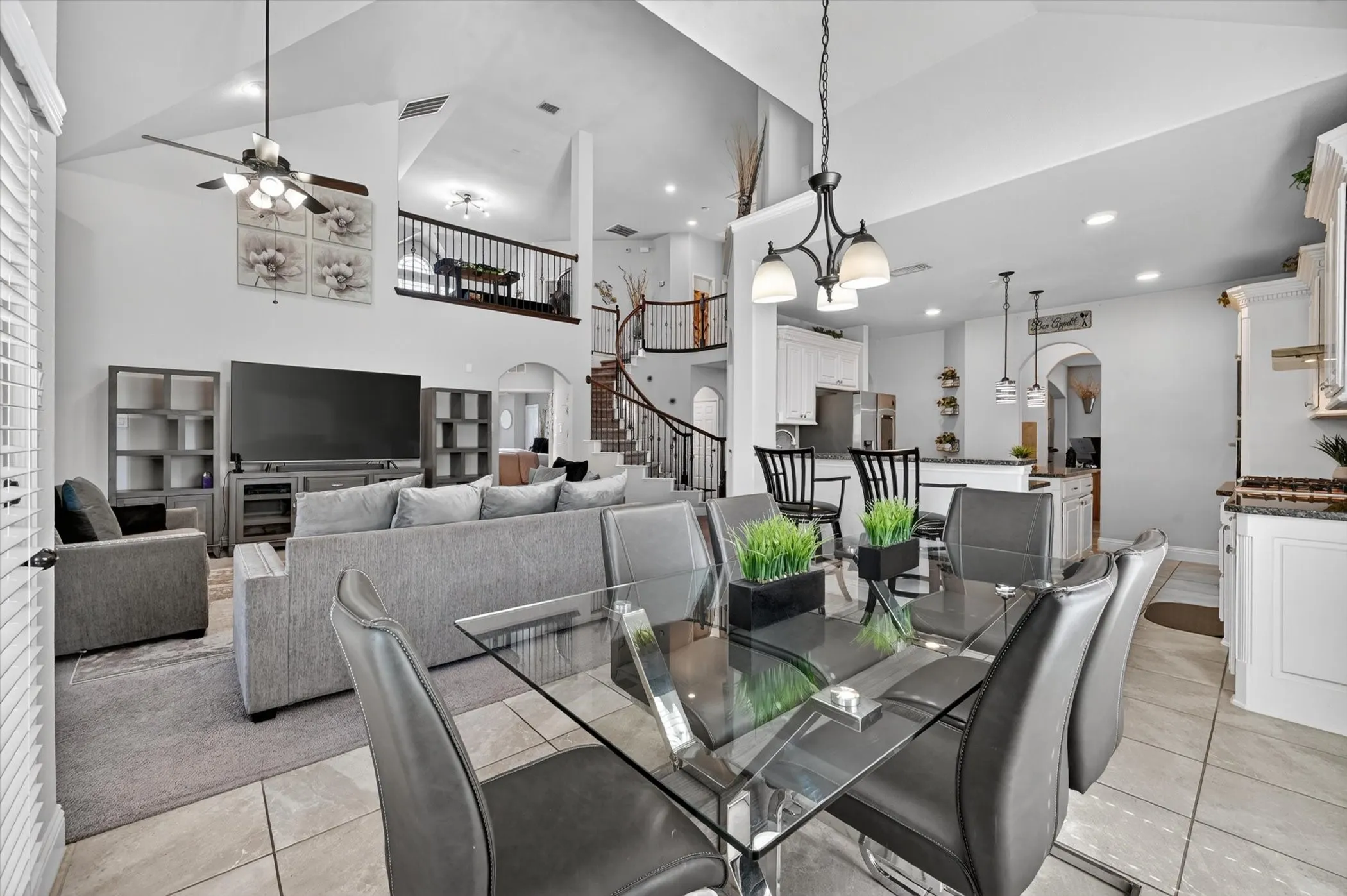 Open-concept living area featuring a vaulted ceiling, recessed lighting, and tile flooring