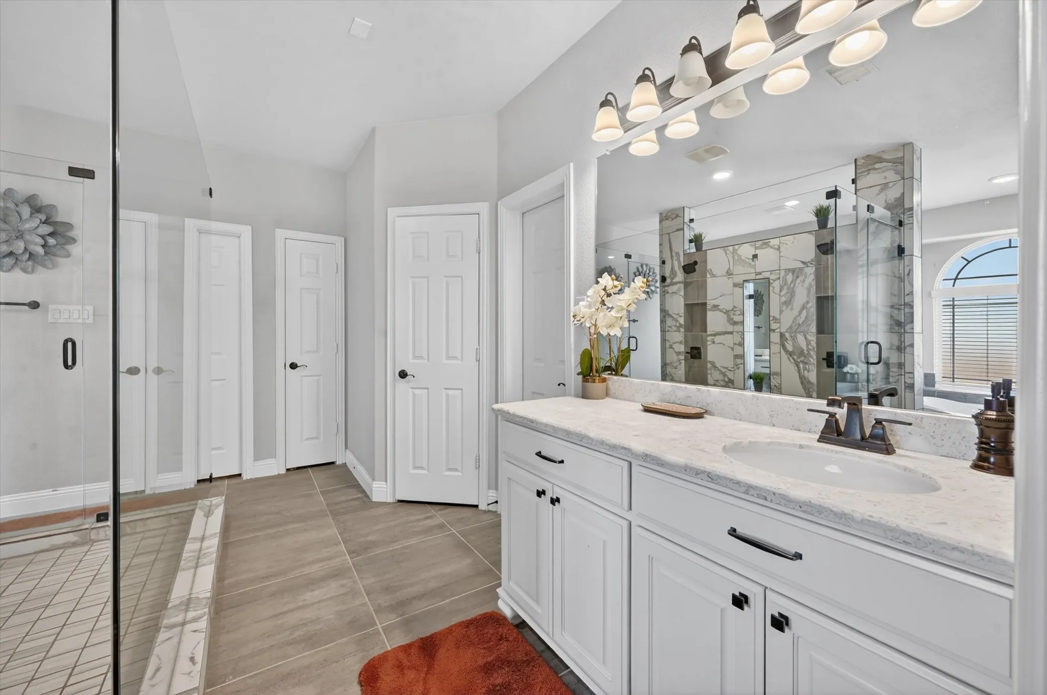 Primary Bath Double vanity with a light-toned countertop, under-mount sink, and bronze-finish faucet