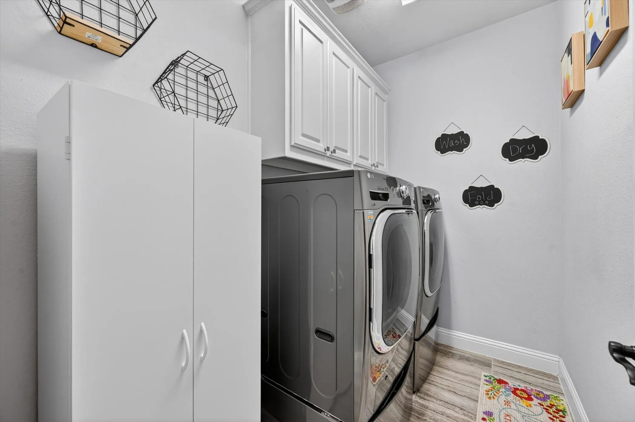 Laundry room featuring white shaker-style upper cabinetry and a full-height white storage cabinet
