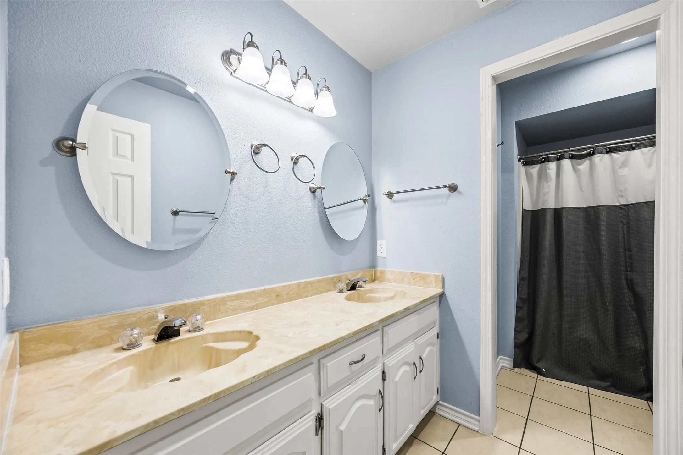 Dual vanity featuring light-toned countertops and integrated sinks