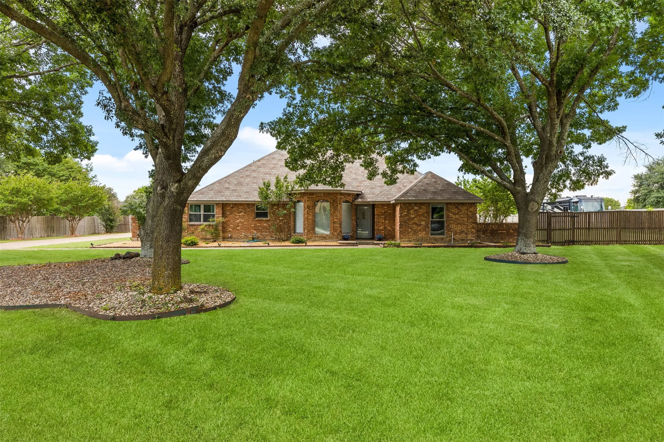 Brick exterior residence featuring a gabled roofline and an arched entryway