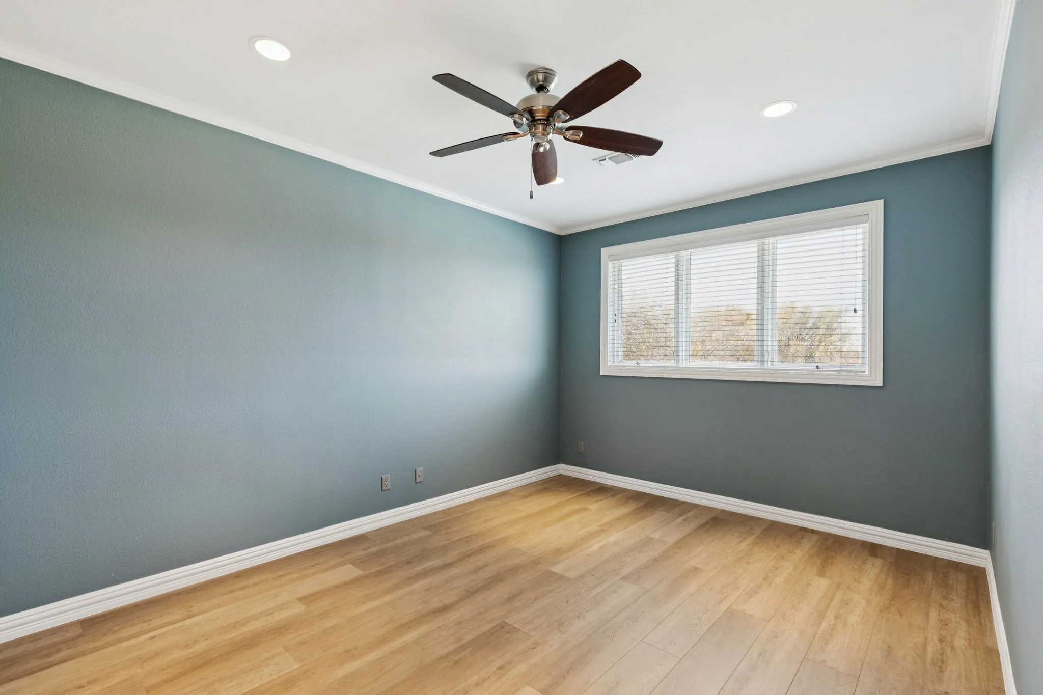 Room featuring wood-finish flooring, a ceiling fan, recessed lighting, and a multi-pane window with blinds