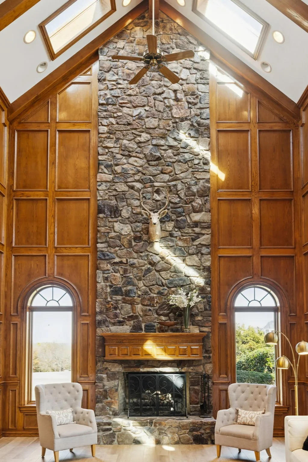 Soaring two-story stone fireplace with a wood mantel