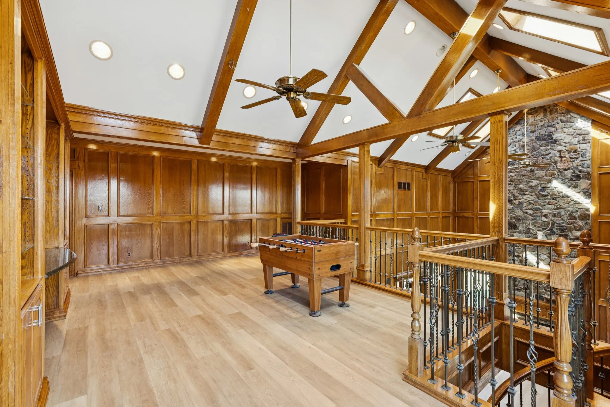 Vaulted ceiling with exposed wood beams, skylights, and recessed lighting
