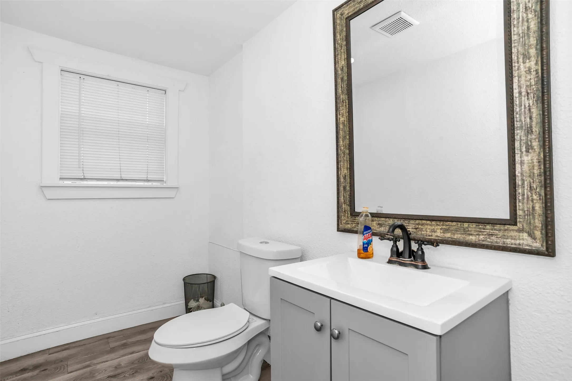 Bathroom featuring a single vanity with a white countertop and gray cabinetry