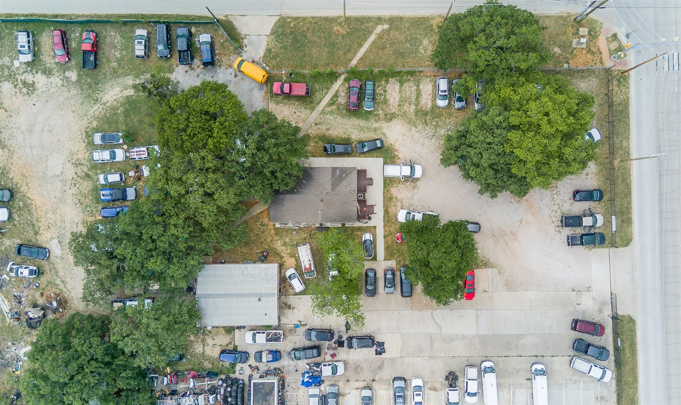 Aerial perspective showcasing a parcel with multiple structures and extensive paved and unpaved areas