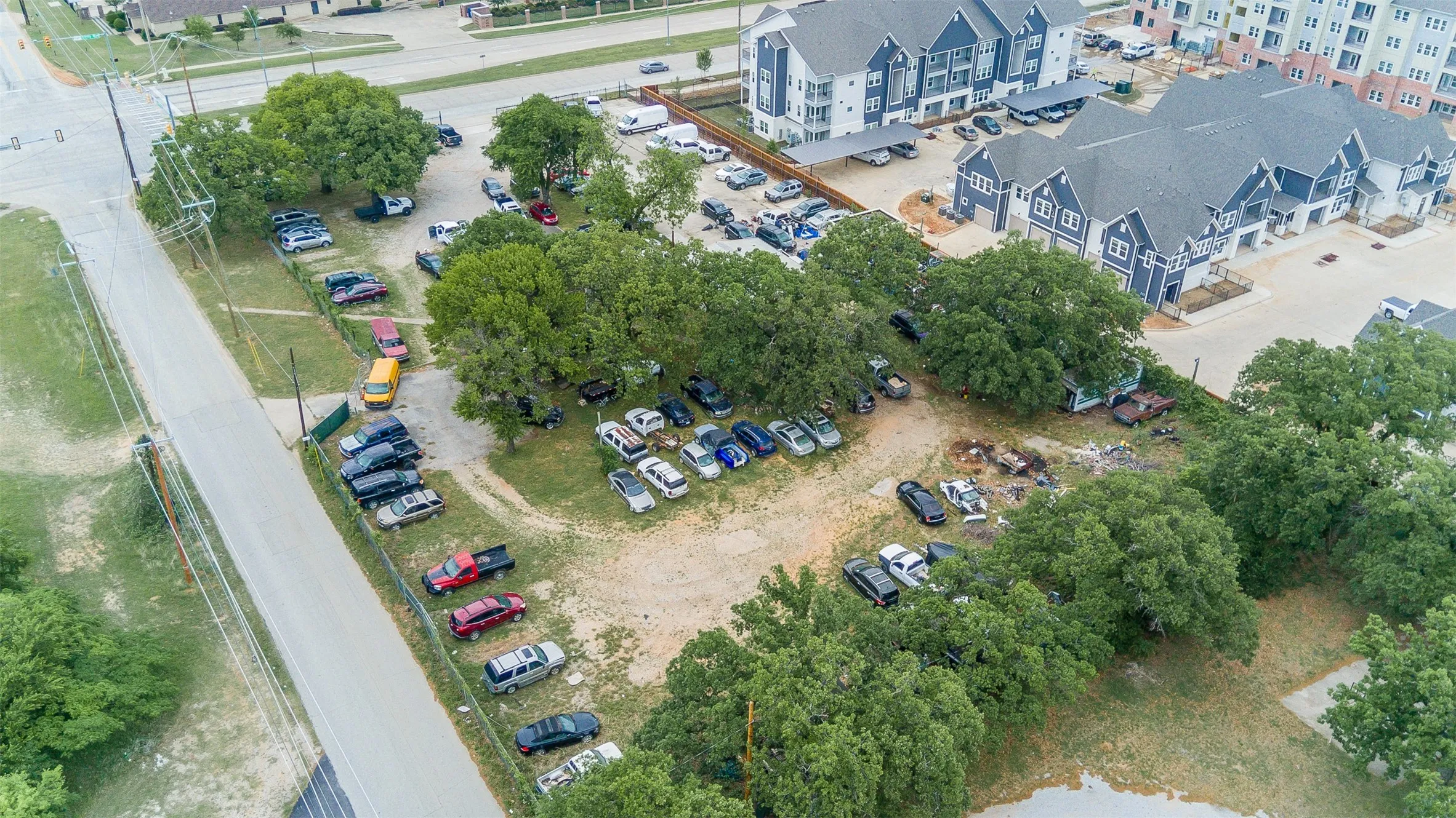 Expansive undeveloped lot featuring mature trees and perimeter fencing