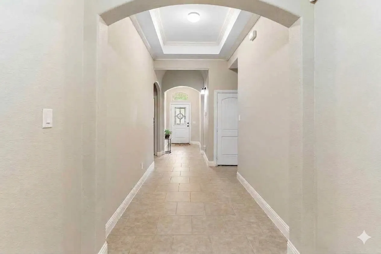 Arched doorways, tray ceiling, tile flooring, and white trim