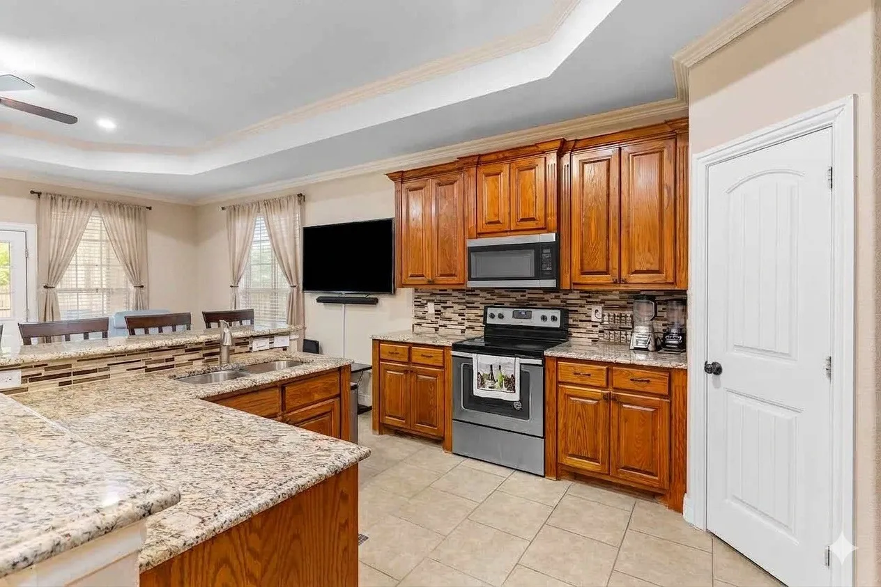 Kitchen featuring granite countertops, wood cabinetry, stainless steel appliances, and a tiled backsplash