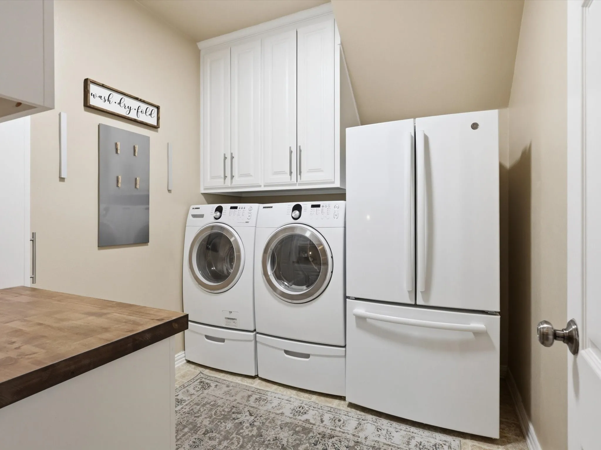 A dreamy laundry room with a sink and extra fridge. All appliances are negotiable!