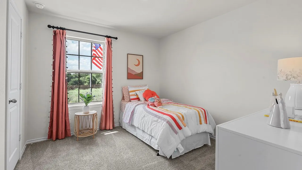 White-painted room featuring a single window with dark hardware, a paneled door with a round handle, light gray carpet flooring, and a recessed ceiling light