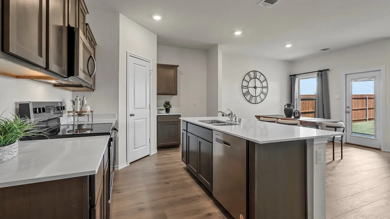 Modern kitchen featuring a central island with an undermount sink, a built-in dishwasher, and ample counter space